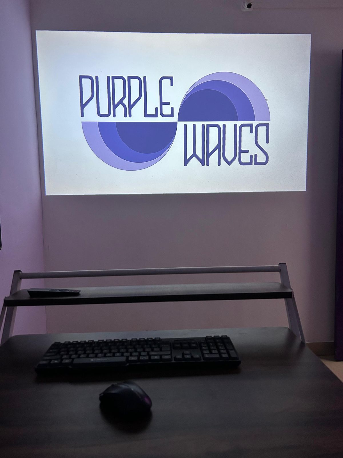 Purple Waves logo projected in the studio
